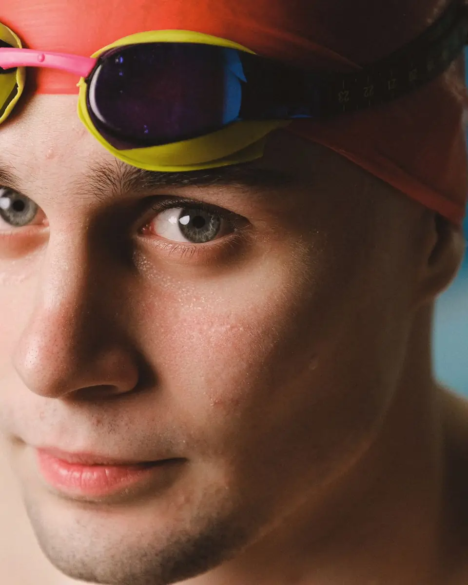 Portrait d’un nageur avec bonnet et lunettes relevées sur le front